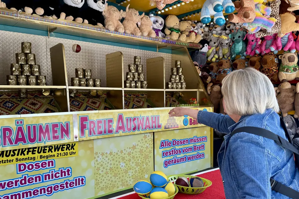 Anja Mattausch und eine Seniorin beim Dosenwerfen auf dem Volksfest